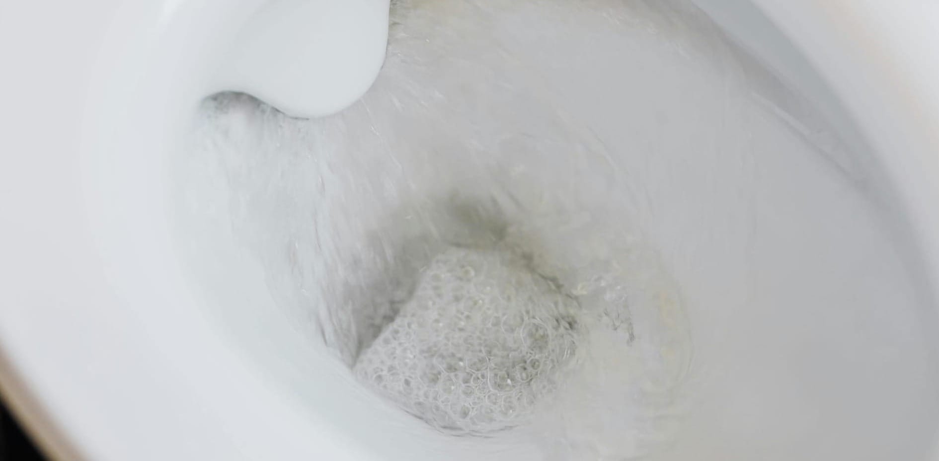 The inside of a toilet bowl being flushed.